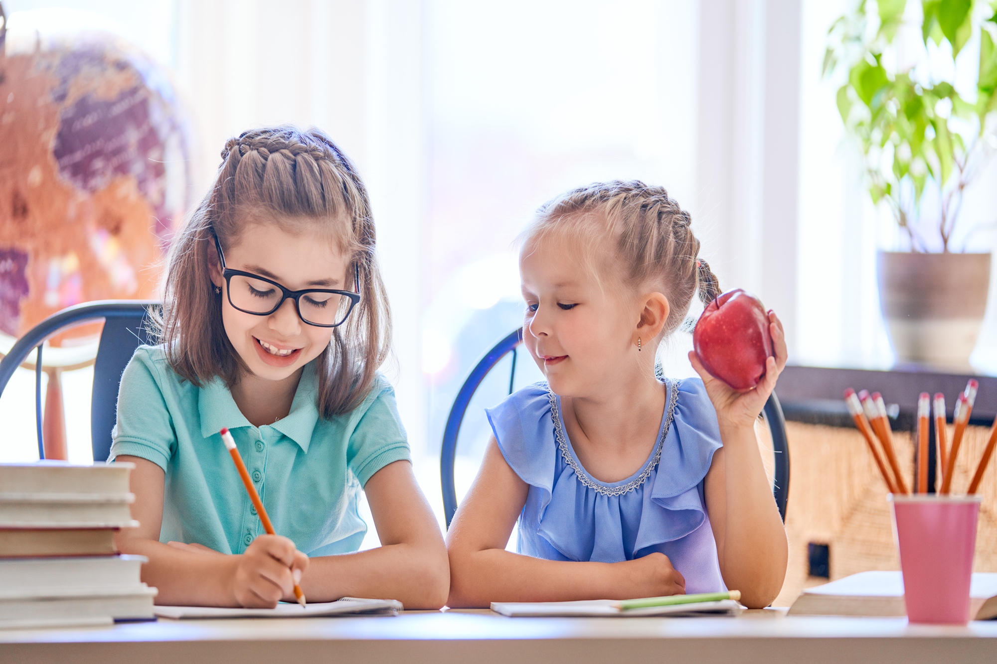 Back to school! Happy cute industrious children are sitting at a desk indoors. Kids are learning in class.