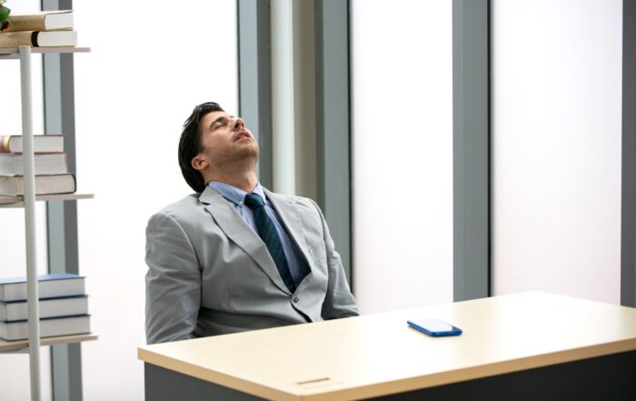 Man in business attire asleep at his desk