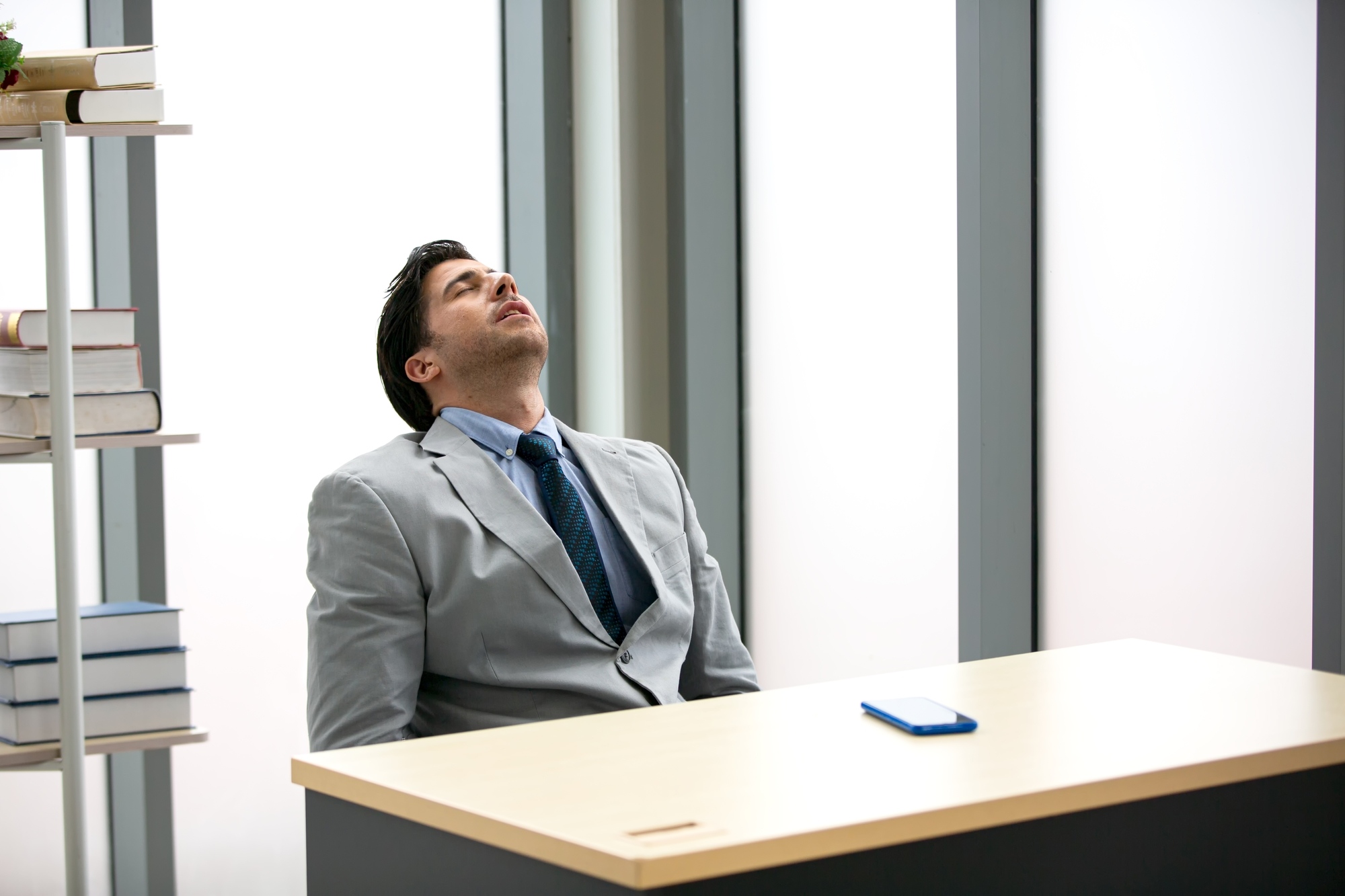 Man in business attire asleep at his desk